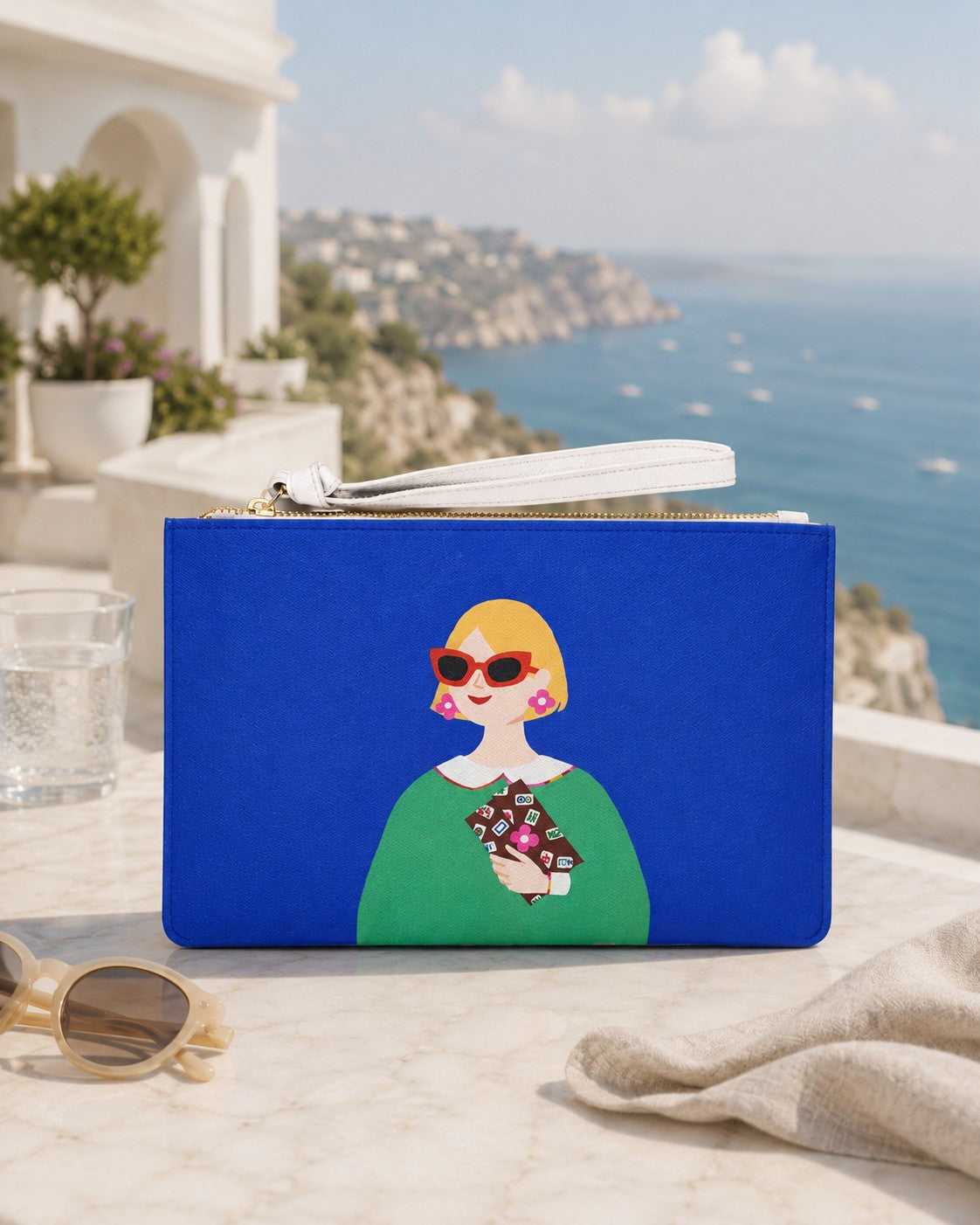 Lucky Tiles clutch bag displayed outdoors with a coastal view in the background