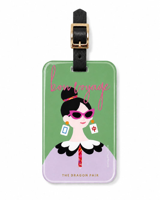 The Dragon Pair luggage tag featuring a stylish modern muse with dragon tile inspired earrings and bold sunglasses against a soft green background